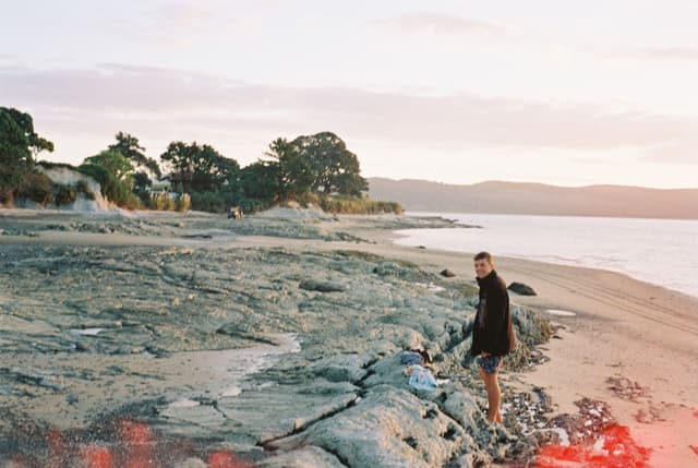 Beach Ocean Rocks Sand Person Trees Sky Clouds Horizon Water Shoreline Landscape Outdoors Nature Sunrise Sunset Walking Blue