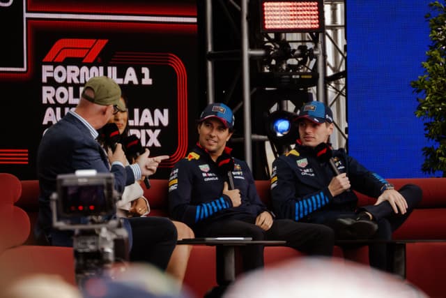 F1 Formula 1 Australian Grand Prix interview stage microphones caps jackets logos red blue black chairs people audience screens plants lights conversation event sports racing discussion panel