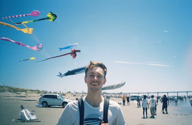 kites beach sky people car sand ocean pier blue colorful flying sunny outdoors festival fun summer day activity gathering shoreline horizon