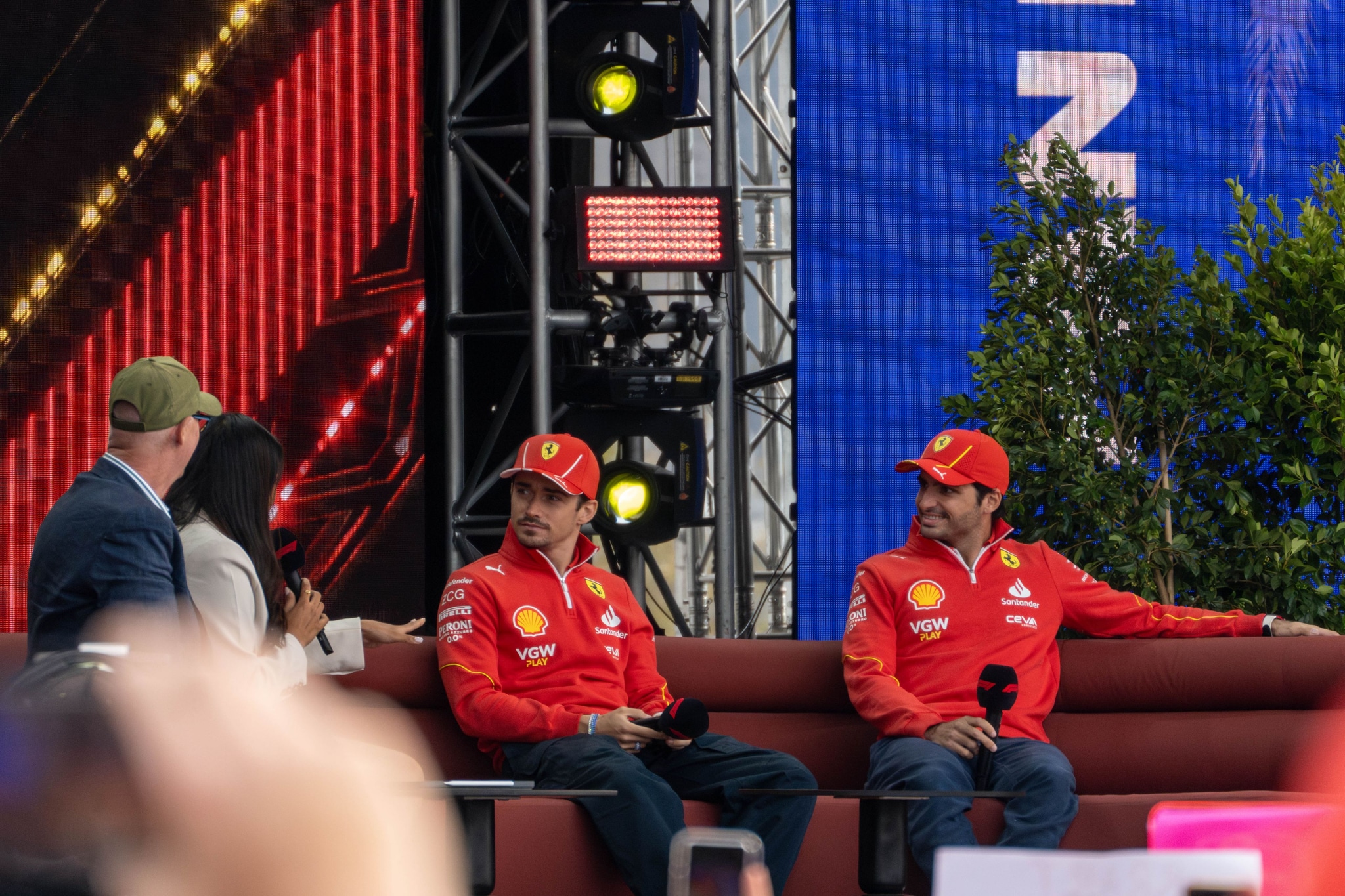 People Couch Microphones Hats Red Blue Green Stage Lights Trees Screens Conversation Event