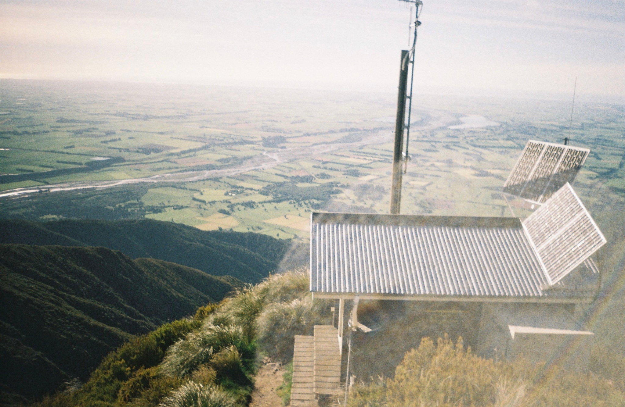 landscape solar-panels antenna hill grass sky horizon valley river green blue structure platform technology nature outdoor equipment renewable-energy viewpoint scenery environment power-generation sustainable energy-source
