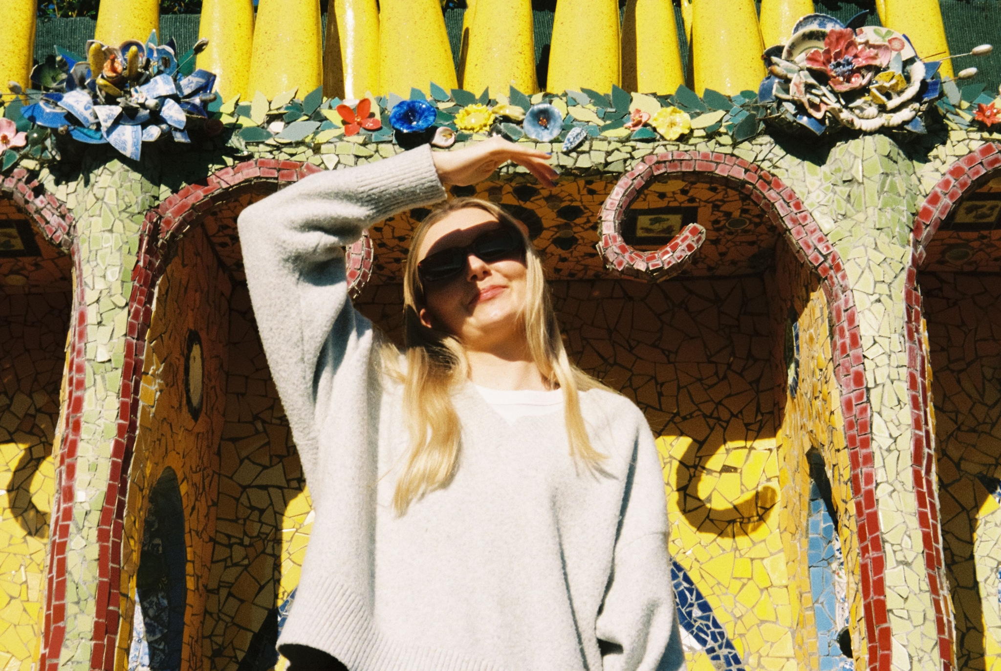 woman sunglasses sweater mosaic art flowers yellow blue green red pink architecture sunlight shadow pattern design texture outdoor casual fashion style decorative colorful bright vibrant