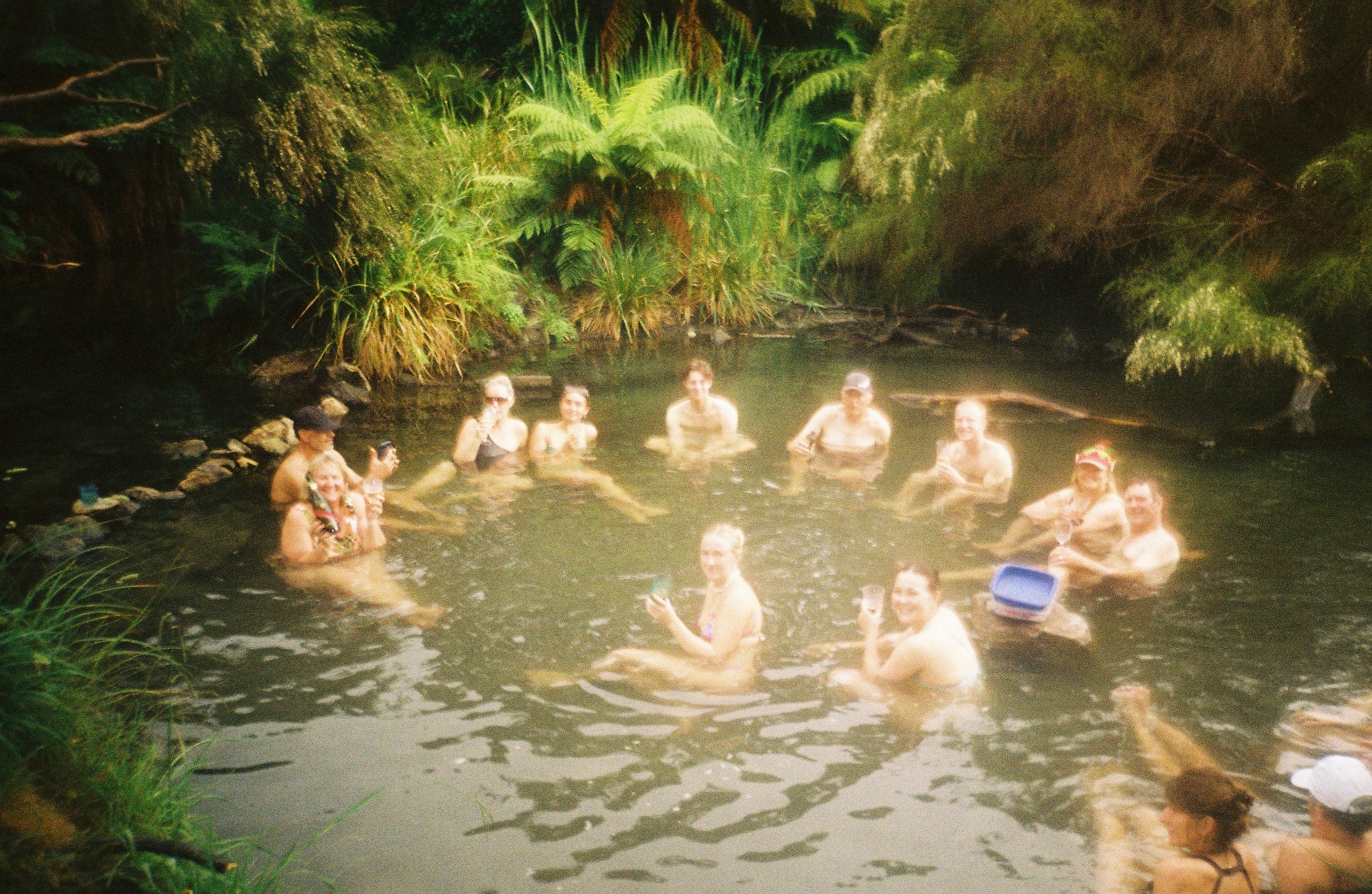 people water pond swimming nature greenery plants trees ferns outdoor group gathering relaxation leisure summer sunlight reflection natural environment forest foliage landscape bathing recreation fun enjoyment vacation travel adventure exploration wilderness scenic peaceful serene tranquil primary green