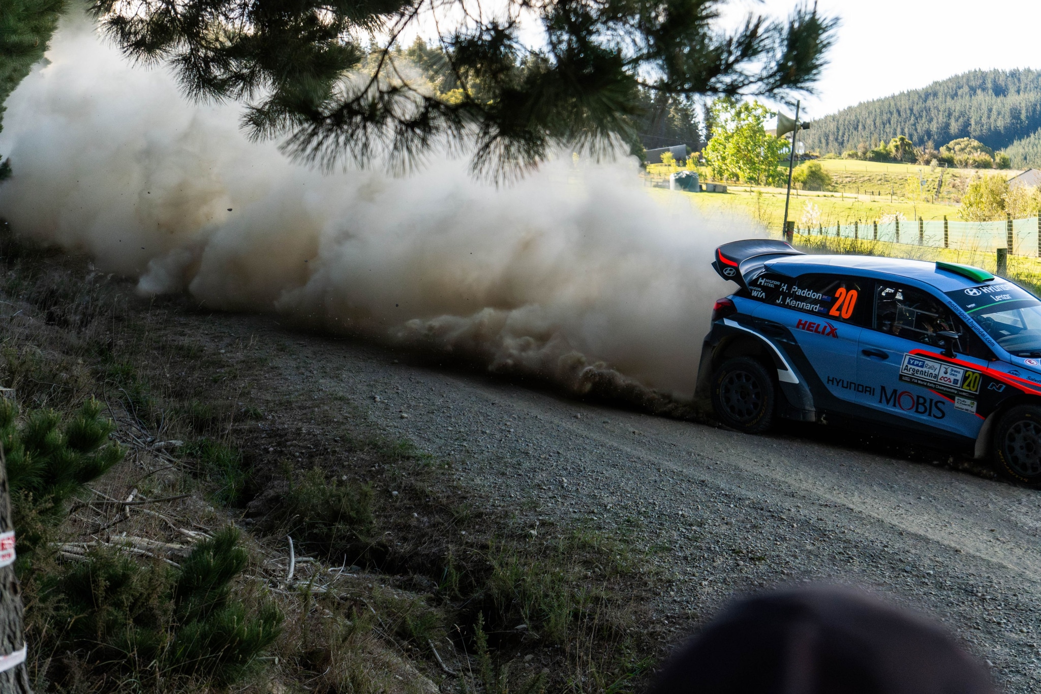 car rally race dirt road dust trees landscape motion speed blue green sky nature action outdoor vehicle competition sport forest countryside adventure excitement dynamic scenery environment track path trail racing energy power performance transportation drive journey travel exploration challenge thrill adrenaline motorsport