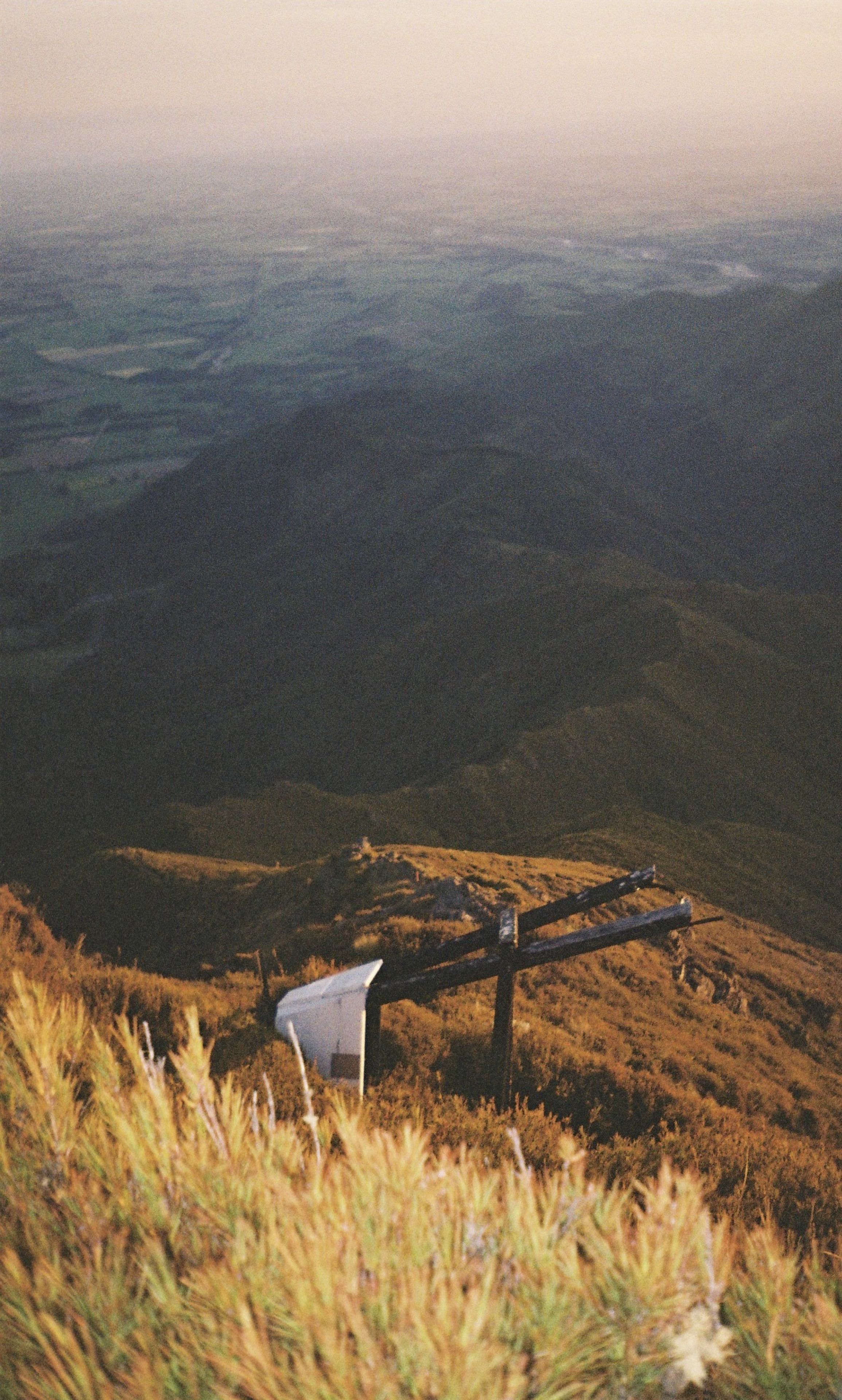 mountain landscape grass hills valley sky horizon sunset sunrise nature outdoors scenery view panorama field vegetation slope peak ridge golden brown green blue yellow sunlight shadow tranquility peaceful remote serene rural countryside travel exploration adventure primary color brown